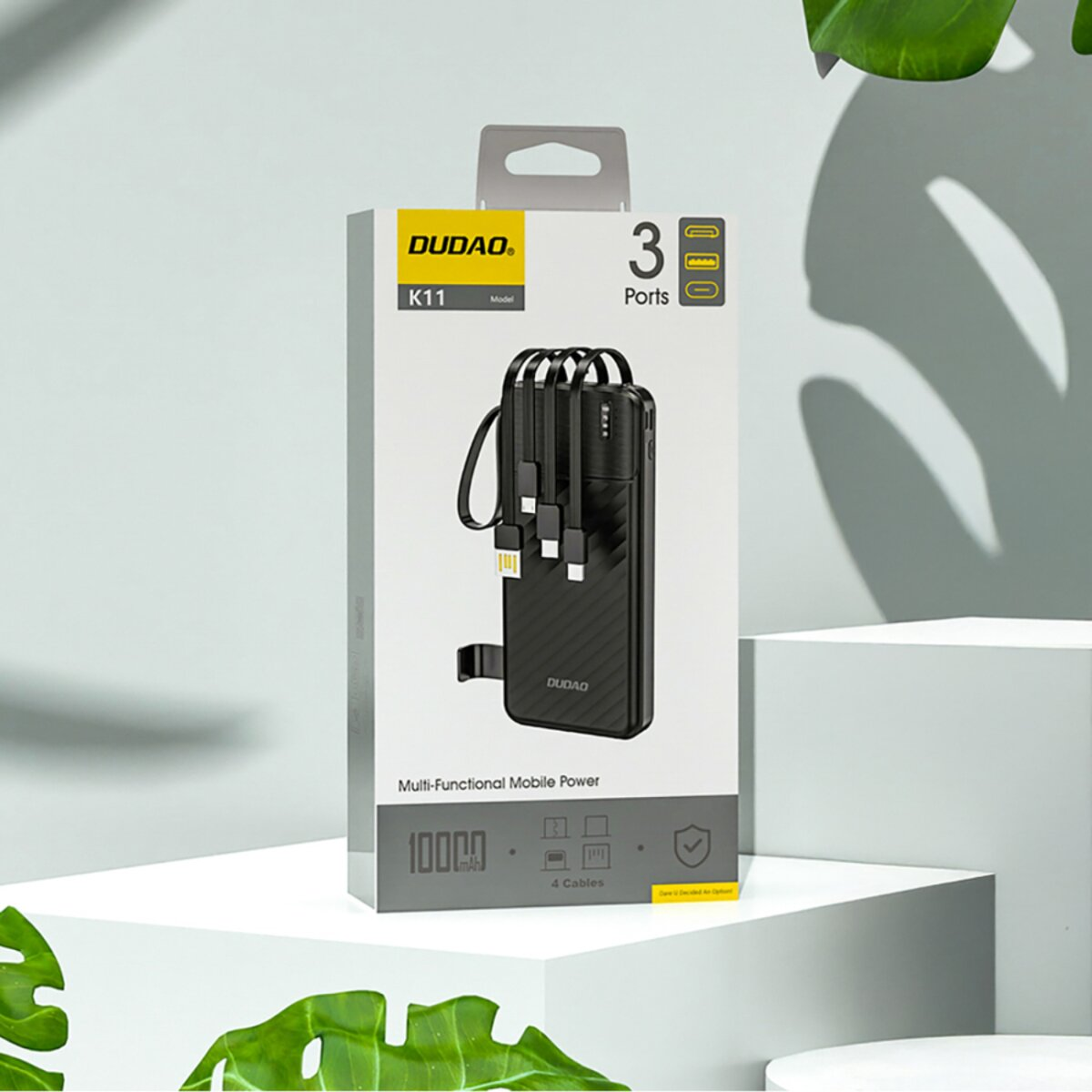 Un power bank DUDÃO K11 è mostrato in una scatola con sfondo bianco. Ha 3 porte e 4 cavi, con una capacità di 10000 mAh.