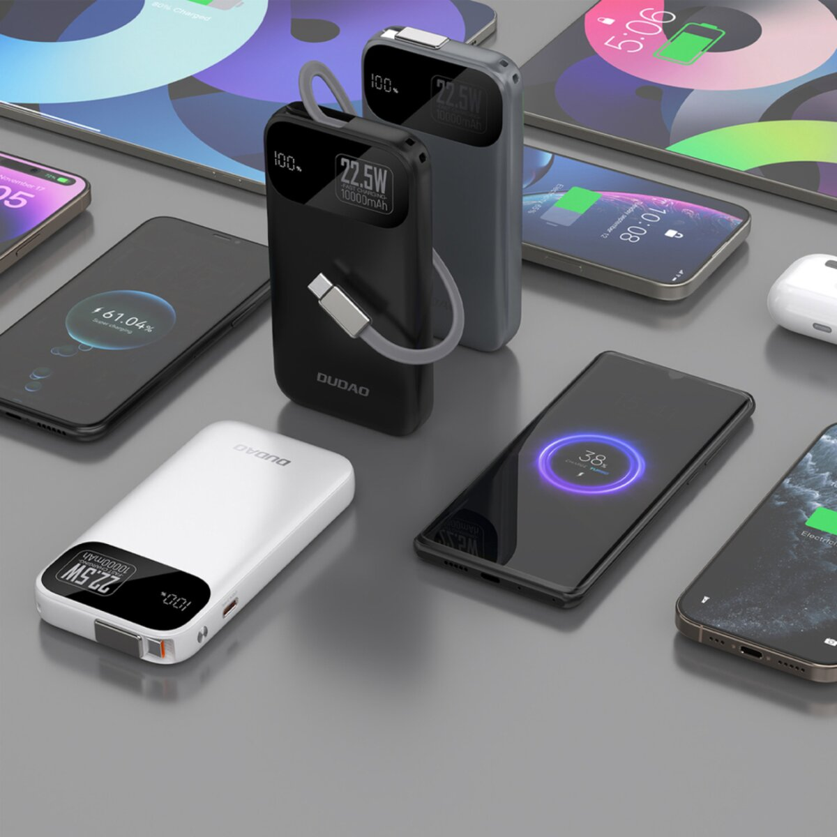 Diversi smartphone e power bank sono disposti su una superficie. I telefoni mostrano schermate di ricarica. I power bank hanno display digitali.