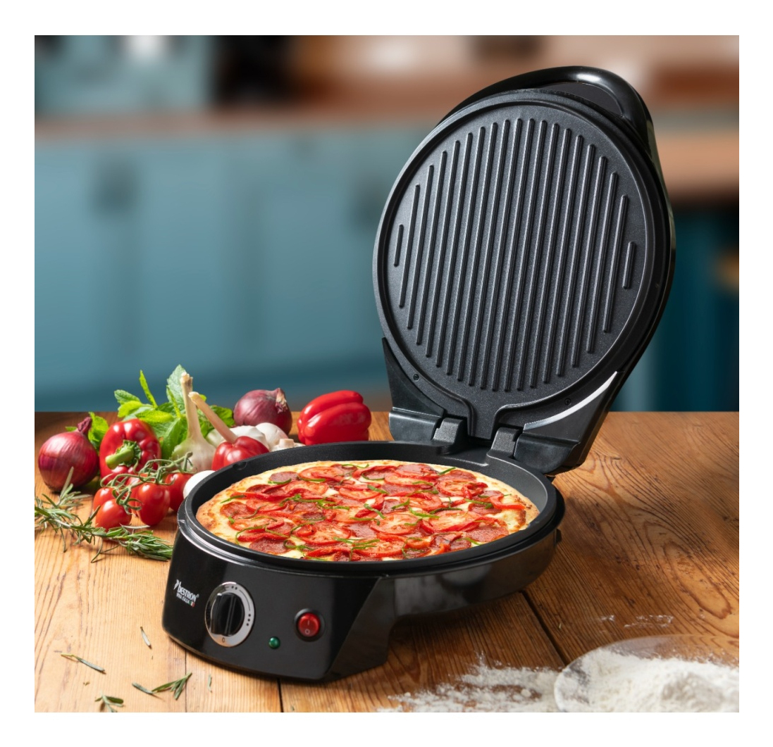 Una macchina per pizza con coperchio aperto, una pizza cotta all'interno. Verdure come pomodori, cipolle e peperoni sono sul tavolo.