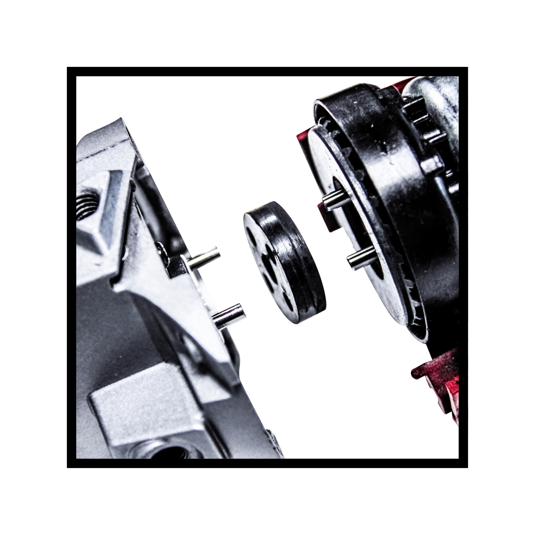 Zbliżenie zdemontowanych części maszyn. Metalowe elementy z kołkami i okrągłą czarną częścią.