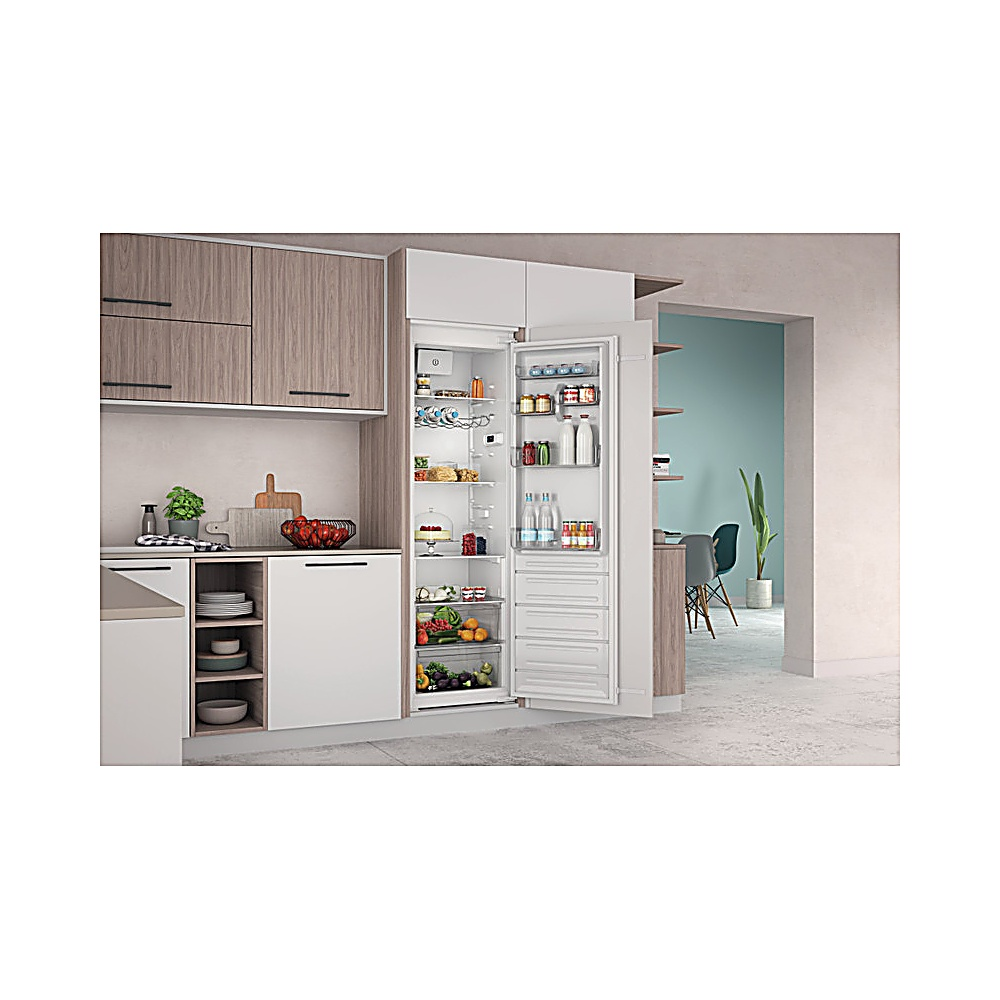 Frigorifero aperto in una cucina moderna. Frutta, verdura e altri alimenti sono visibili. Si vedono anche mobili in legno e una zona pranzo.