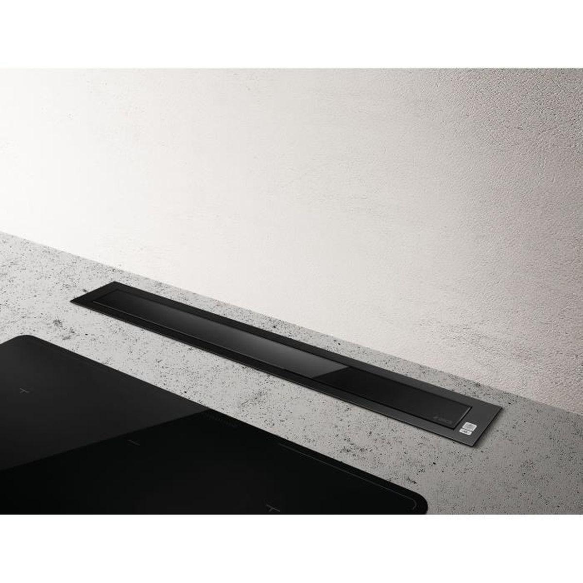 Un moderno piano cottura nero con una cappa abbinata integrata in un piano di lavoro grigio chiaro, contro un muro bianco.