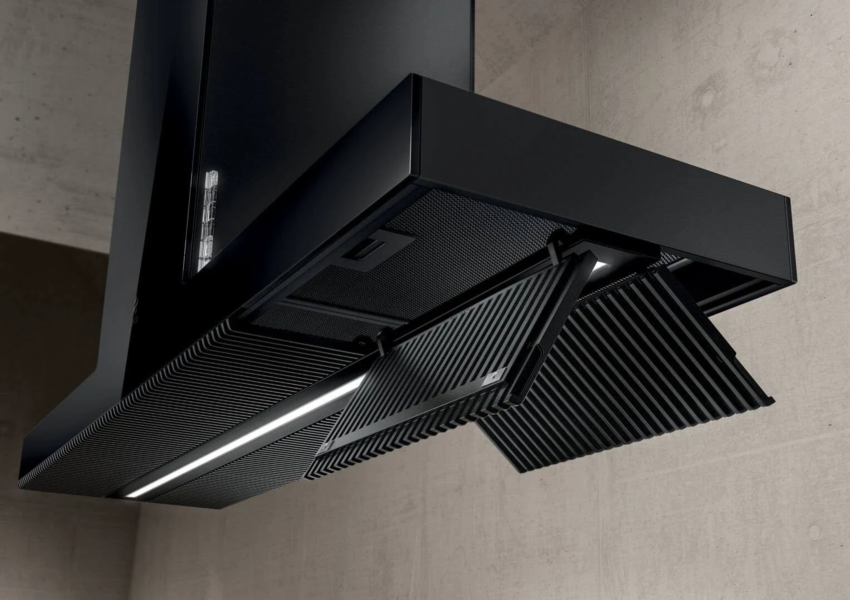 Una moderna cappa da cucina nera con un design geometrico. I filtri sono parzialmente aperti e lo sfondo è un muro di cemento.