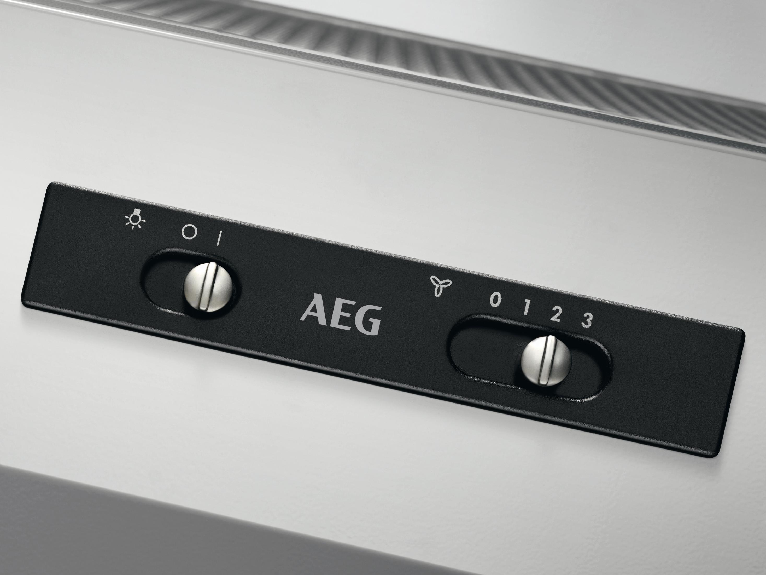Un primo piano di un pannello di controllo nero con manopole argentate e il logo AEG. Ha impostazioni luce e ventola.