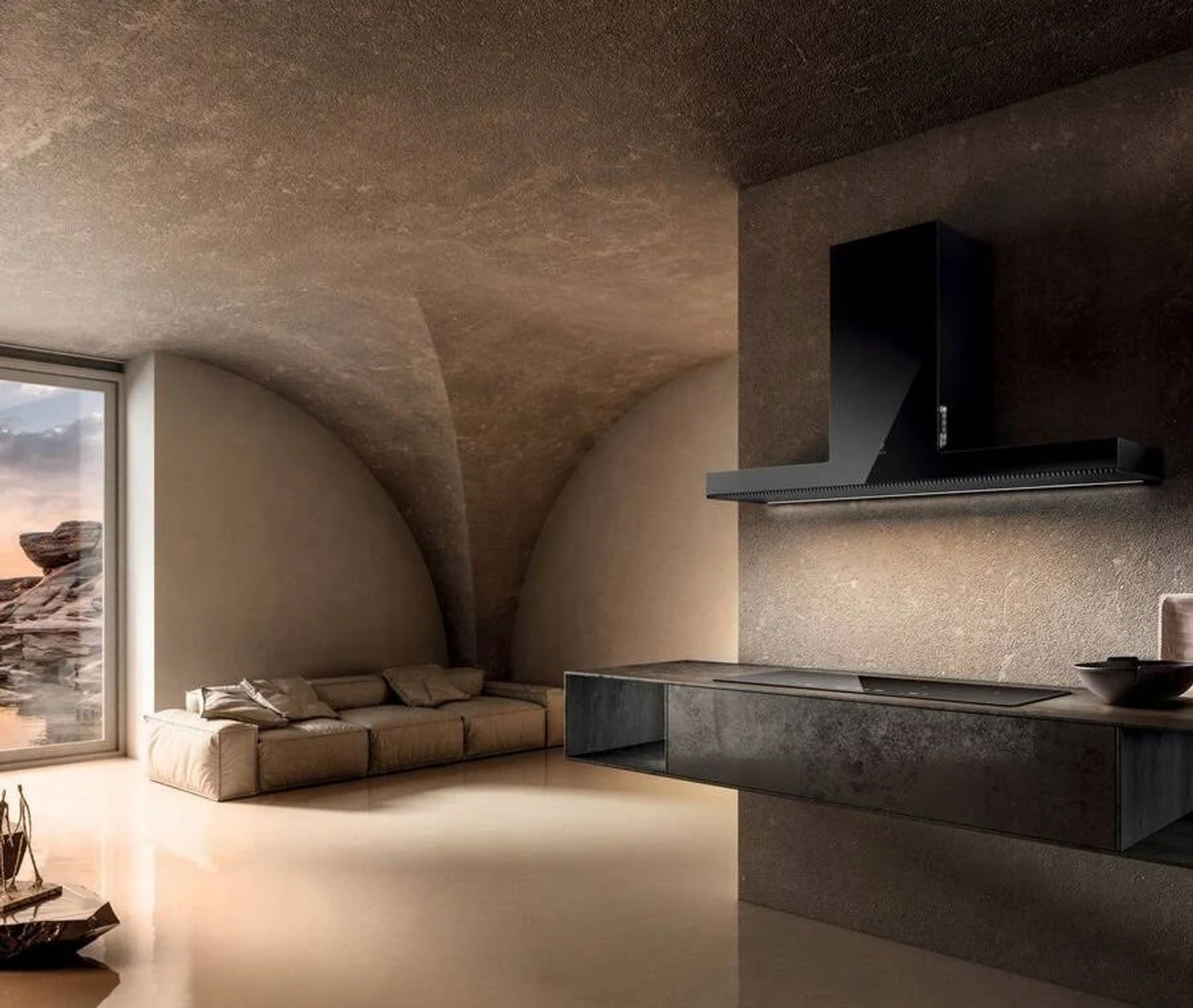 Cucina moderna con cappa nera, bancone e divano. Una finestra mostra una vista del paesaggio. La stanza ha un soffitto curvo.