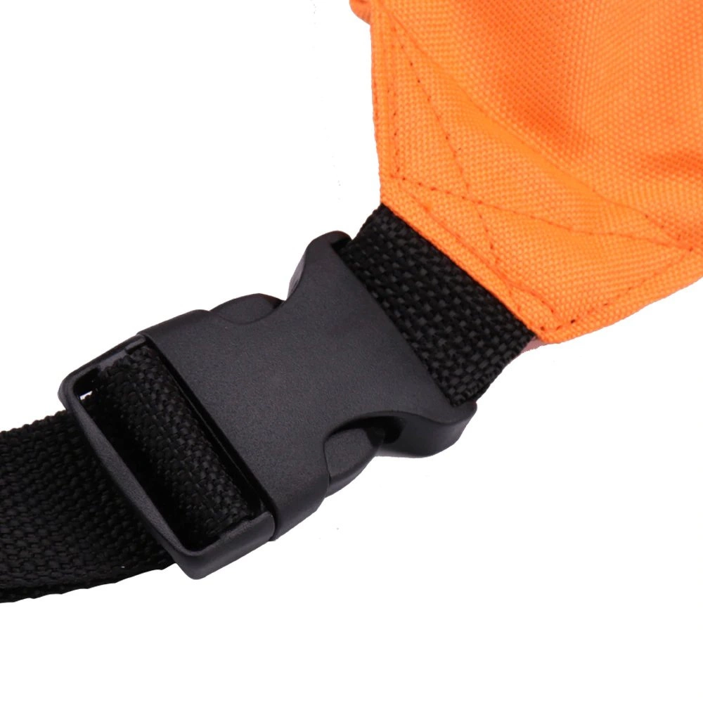 Nahaufnahme einer schwarzen Kunststoffschnalle an einem orangefarbenen und schwarzen Riemen. Der orange Stoff ist genäht. Der Hintergrund ist weiß.