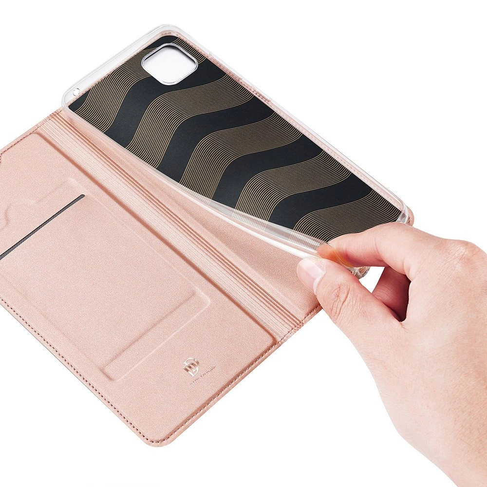 Una mano tiene una custodia per telefono, rivelando il telefono all'interno. La custodia è rosa, il retro del telefono è nero con onde dorate.