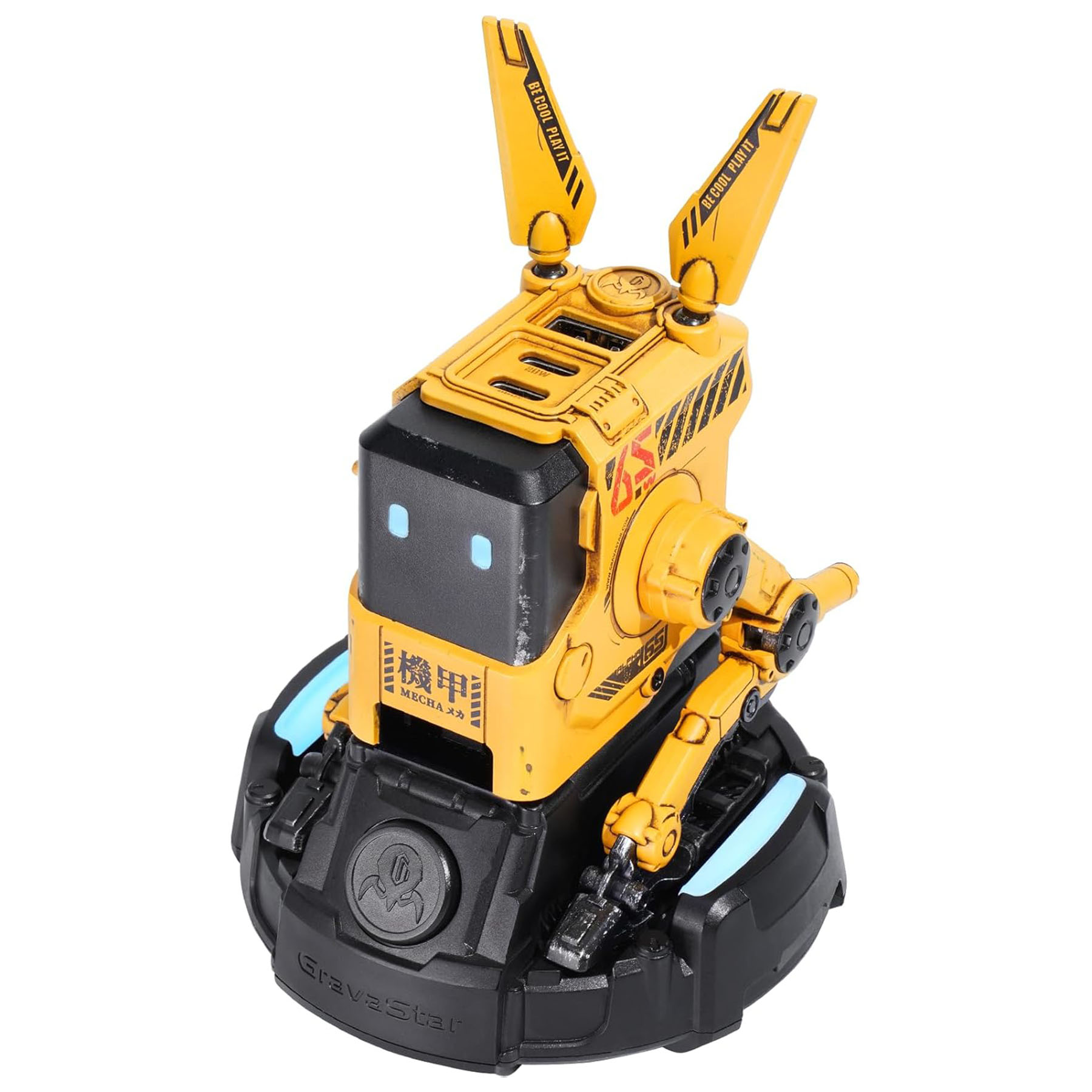 Antenleri ve kolları olan sarı ve siyah bir robot oyuncak, siyah bir taban üzerinde oturuyor. Robot üzerindeki metin 'Mecha' ve 'Be Cool Play It' yazıyor.