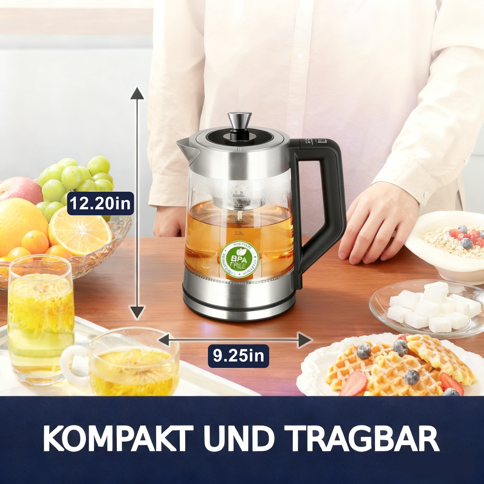 Ein Glasteekessel mit Tee, Obst, Waffeln und Zuckerwürfeln auf einem Holztisch. Eine Person ist im Hintergrund.