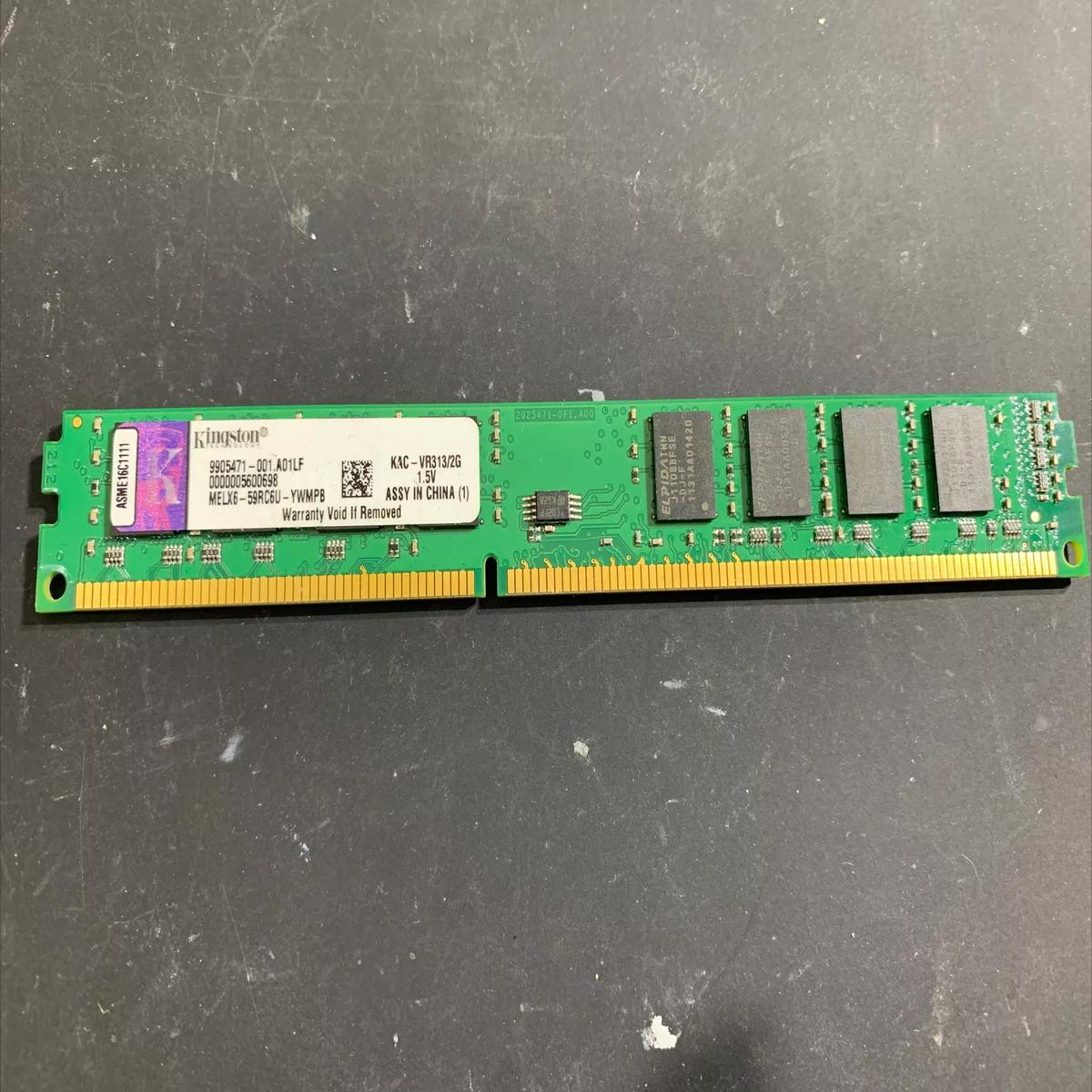 Una memoria RAM verde e oro con chip, marchio Kingston. Su una superficie scura.
