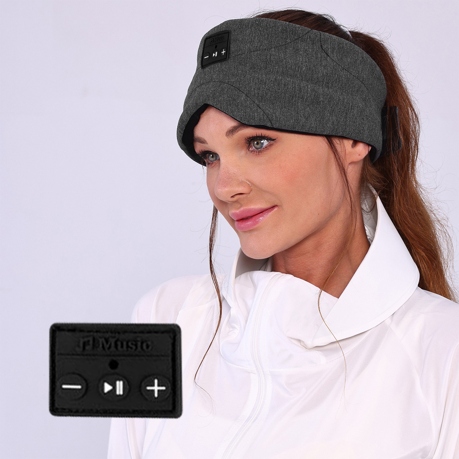 Eine Frau trägt ein graues Stirnband mit Bedienelementen. Sie trägt eine weiße Jacke. Ein schwarzes Gerät mit Musikbedienelementen befindet sich im Vordergrund.