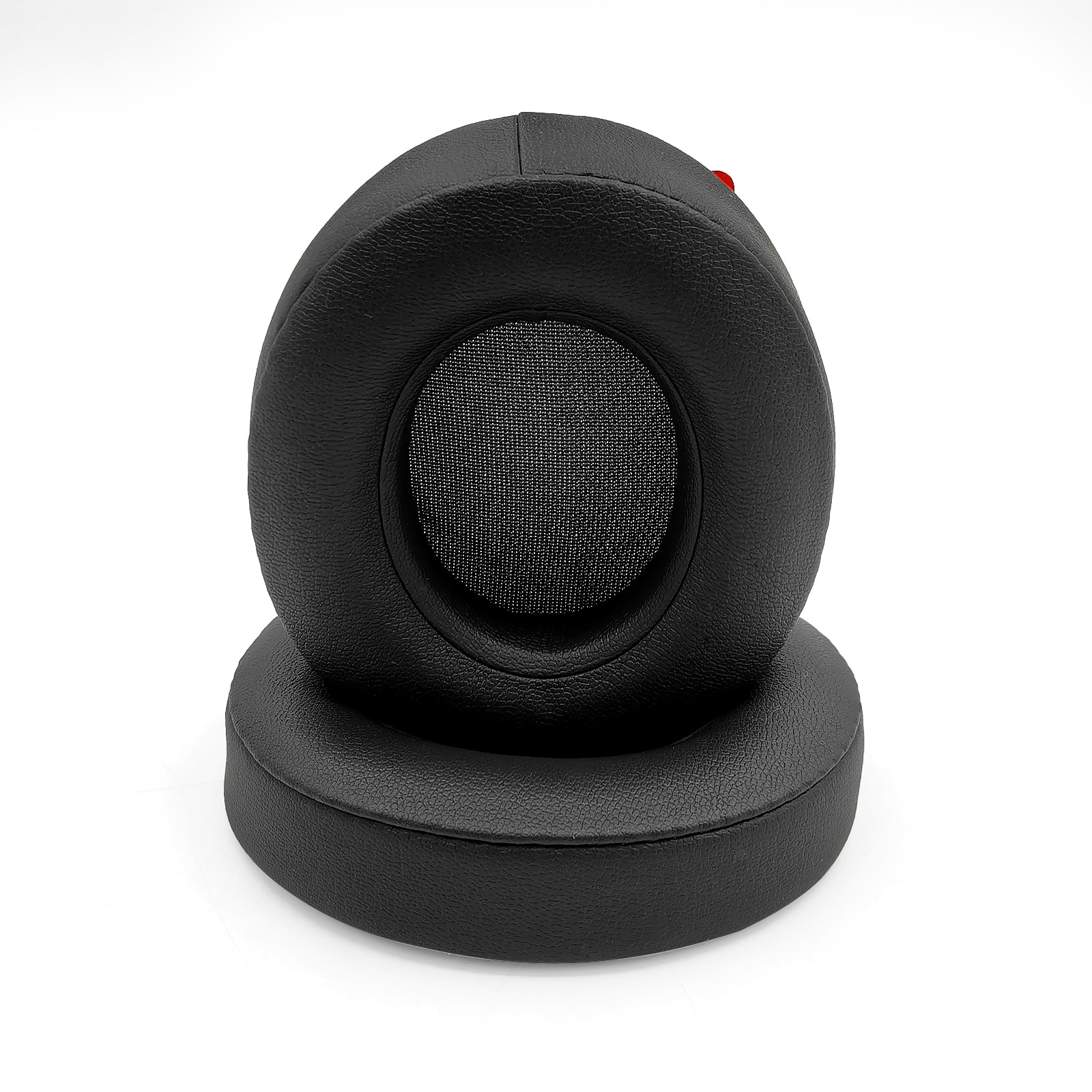 Dos almohadillas negras para auriculares. Una encima de la otra. Fondo blanco. Malla en el centro de las almohadillas.