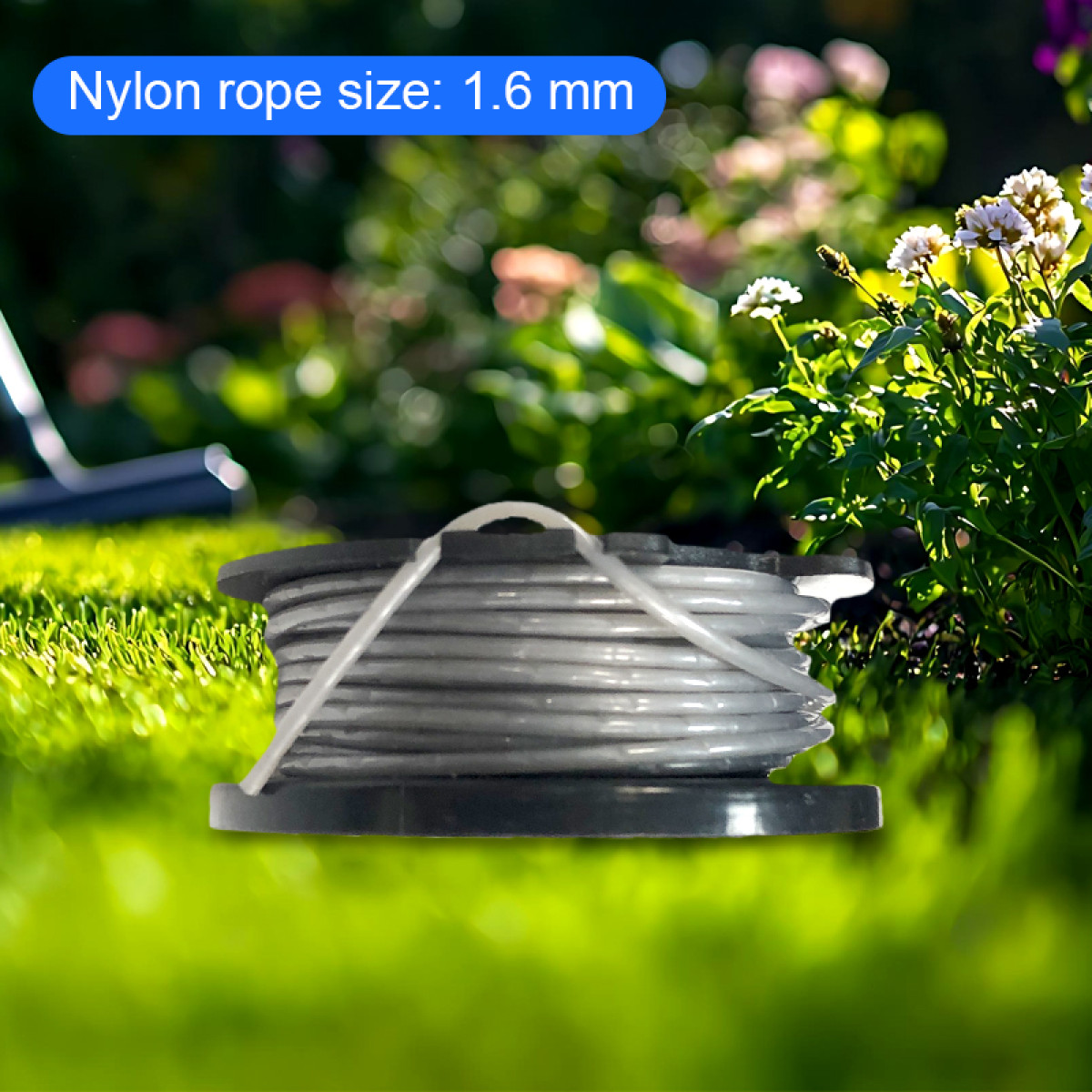 Eine Spule graues Nylonseil, Größe 1,6 mm, liegt auf grünem Gras. Blumen und Blätter sind im Hintergrund.