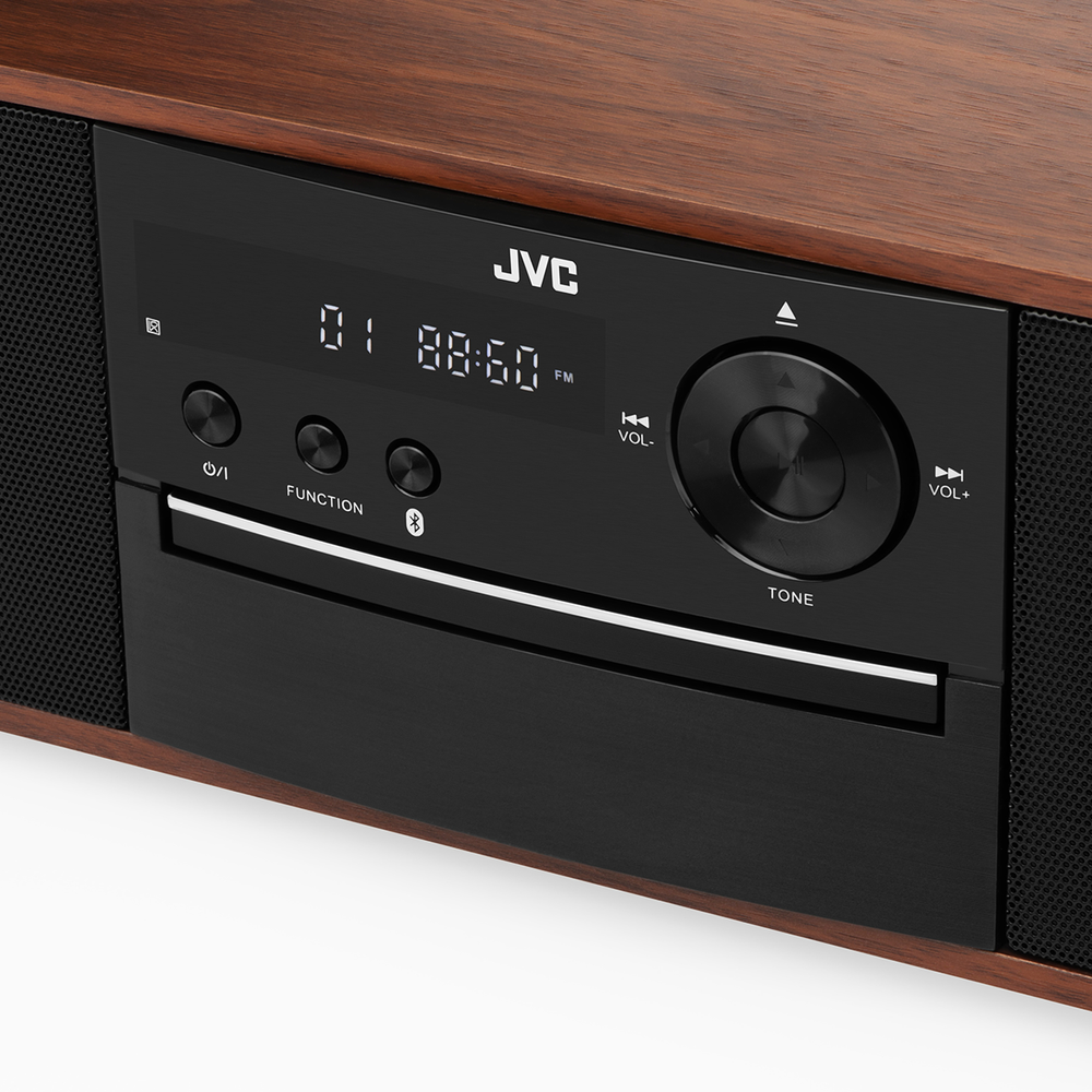 Zbliżenie na system stereo JVC. Ma czarny panel przedni z przyciskami, wyświetlaczem i gniazdem na płyty CD. Rama jest drewniana.