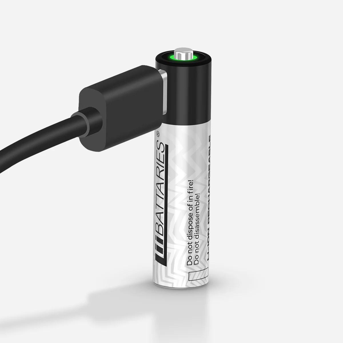 Akumulator z podłączonym kablem ładującym. Bateria jest biało-czarna z zielonym światłem na górze. Cień w tle.