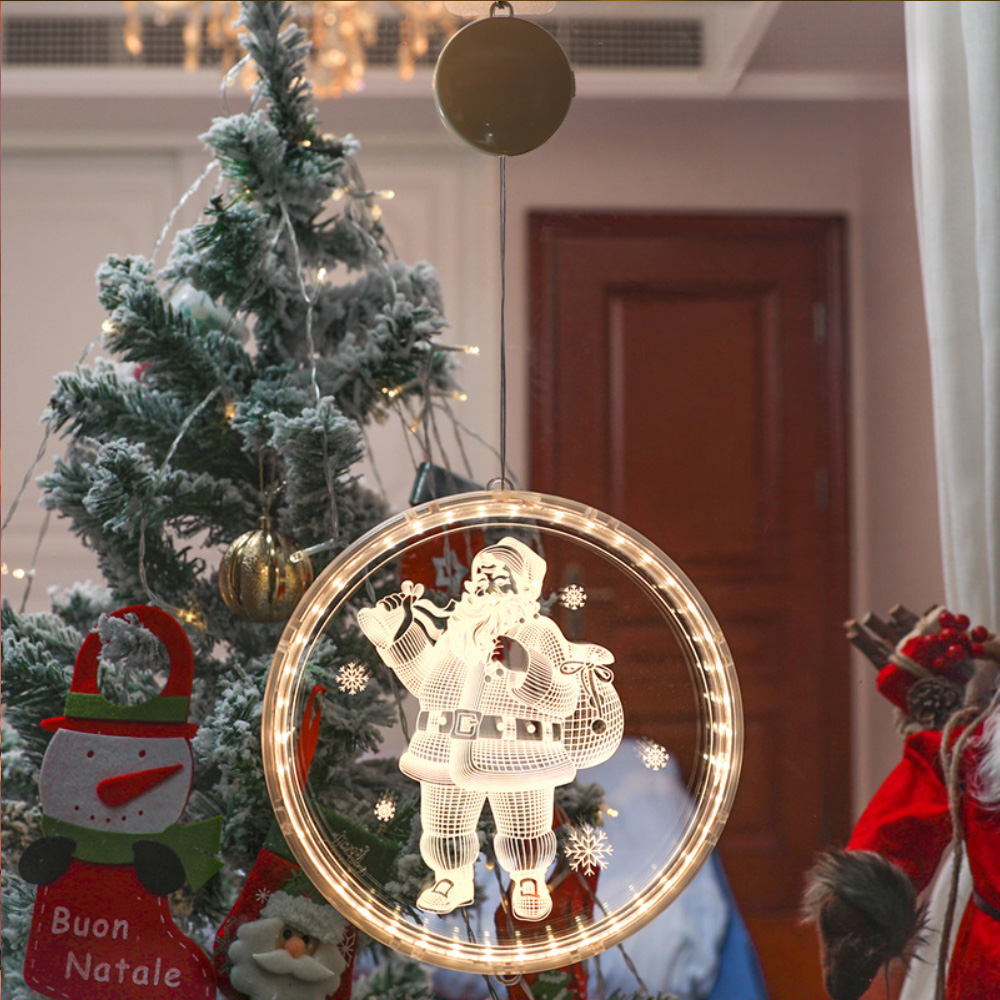 Eine runde Santa Claus Lichtdekoration hängt vor einem Weihnachtsbaum und anderen Weihnachtsdekorationen.