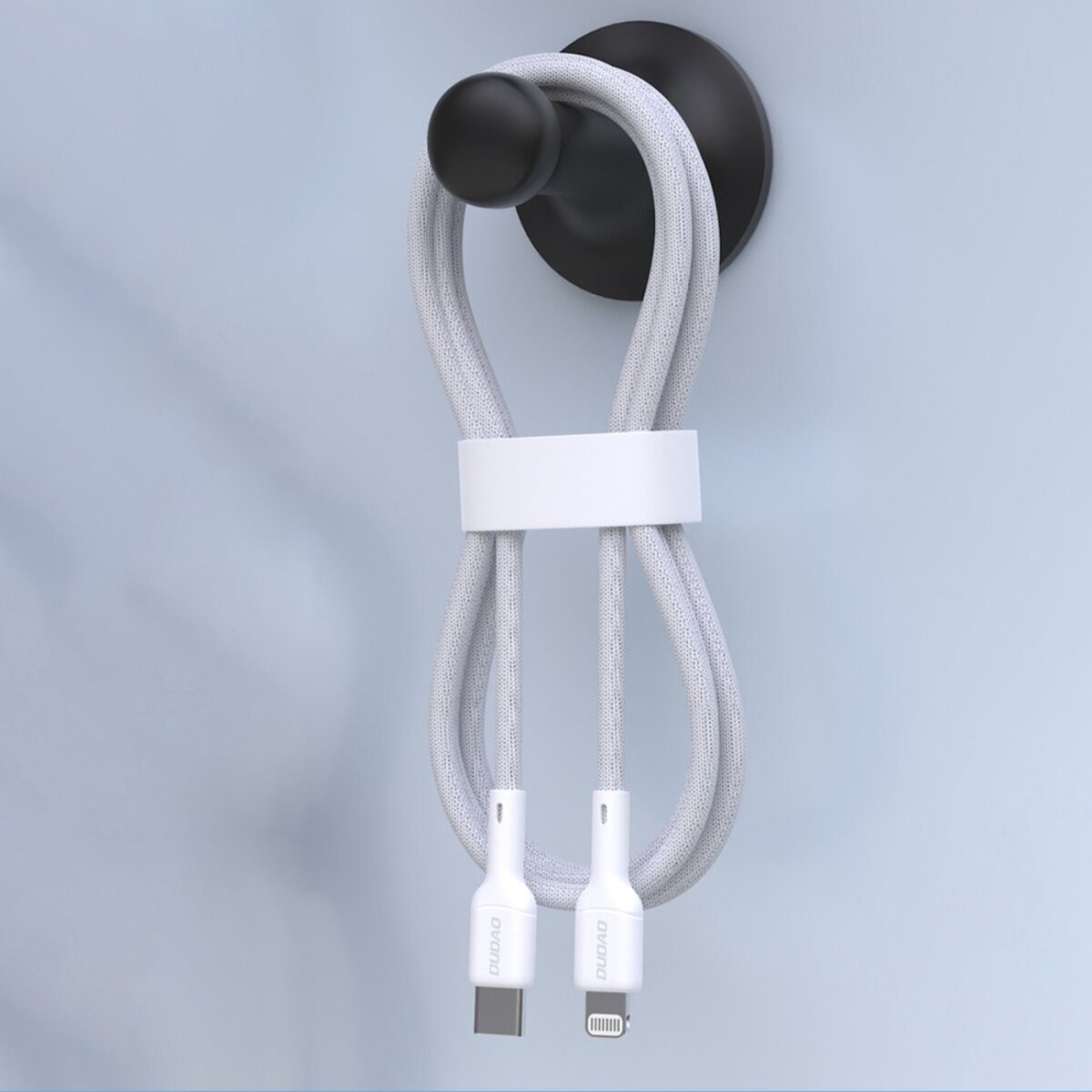 Ein weiß-graues Ladekabel hängt an einem schwarzen Haken. Das Kabel hat zwei weiße Stecker.