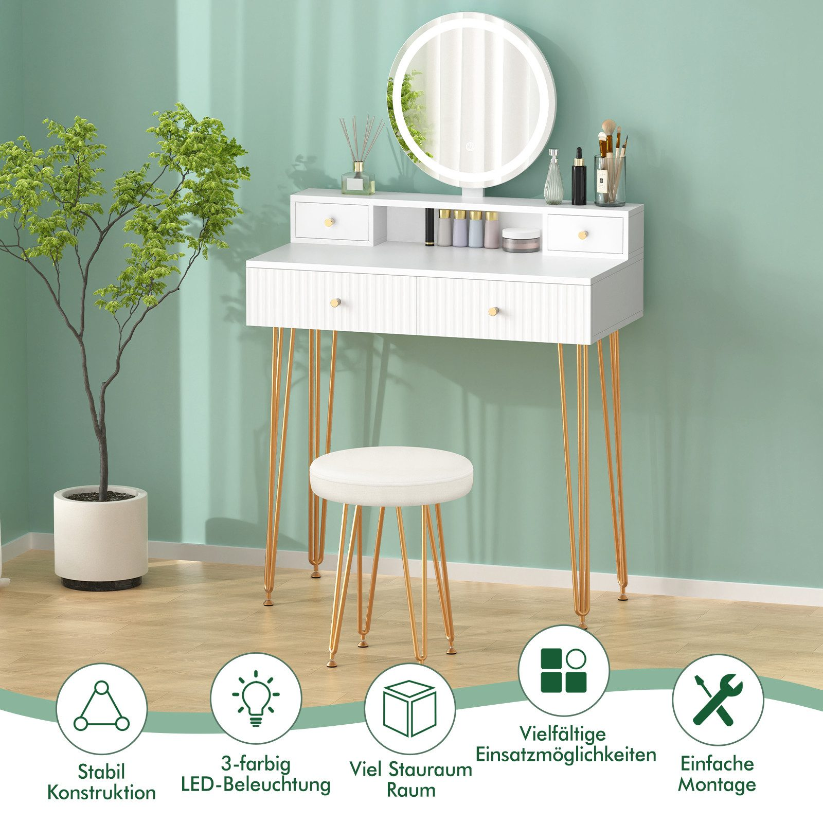 Weißer Schminktisch mit goldenen Beinen, rundem Spiegel und Hocker. Pflanze links. Mintfarbene Wand im Hintergrund.