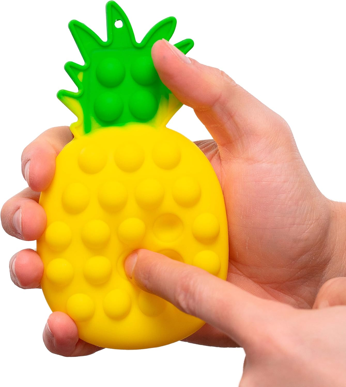 Eine Hand drückt auf ein gelbes, ananasförmiges Spielzeug mit grünen Blättern. Das Spielzeug hat blasenartige Merkmale.