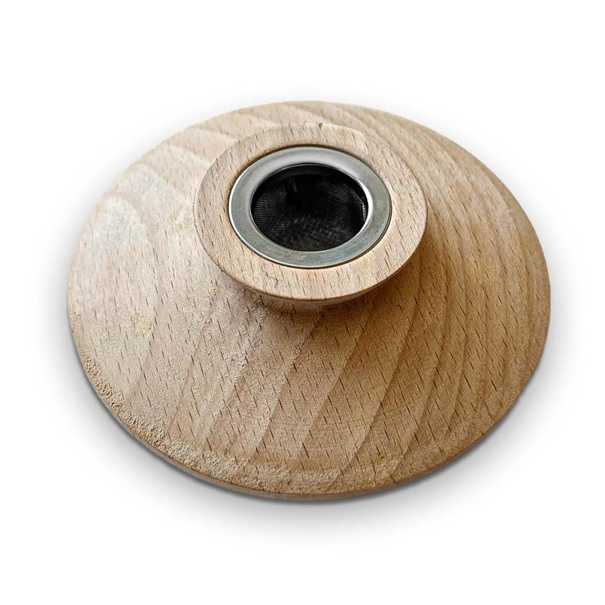 A wooden tea infuser with a metal mesh filter. It has a round base and a raised center. The background is white.