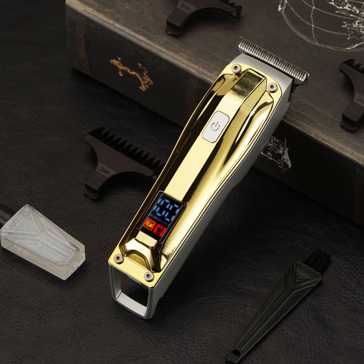 Ein gold-silberner Haarschneider mit Zubehör. Enthält Aufsätze, eine Reinigungsbürste und eine kleine Flasche, alles auf schwarzem Untergrund.