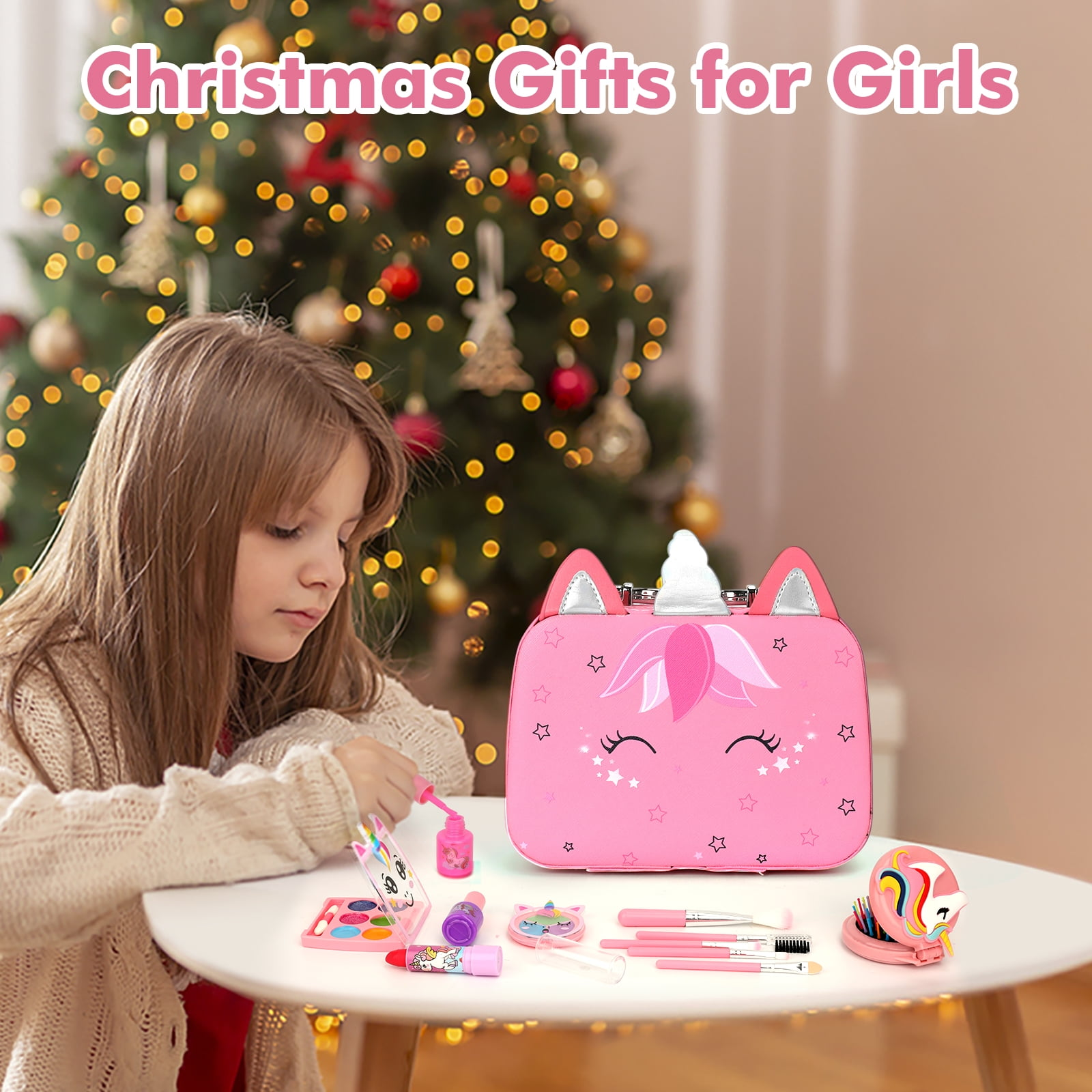 Mädchen mit Make-up-Set. Pinker Einhorn-Koffer, Make-up-Produkte auf weißem Tisch, Weihnachtsbaum im Hintergrund.