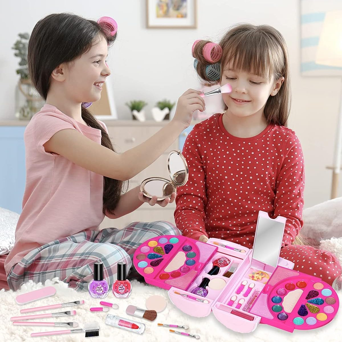 Zwei Mädchen spielen mit Make-up. Eines trägt Rouge auf die Wange des anderen auf. Schminksets und Zubehör liegen auf einem Bett verstreut.