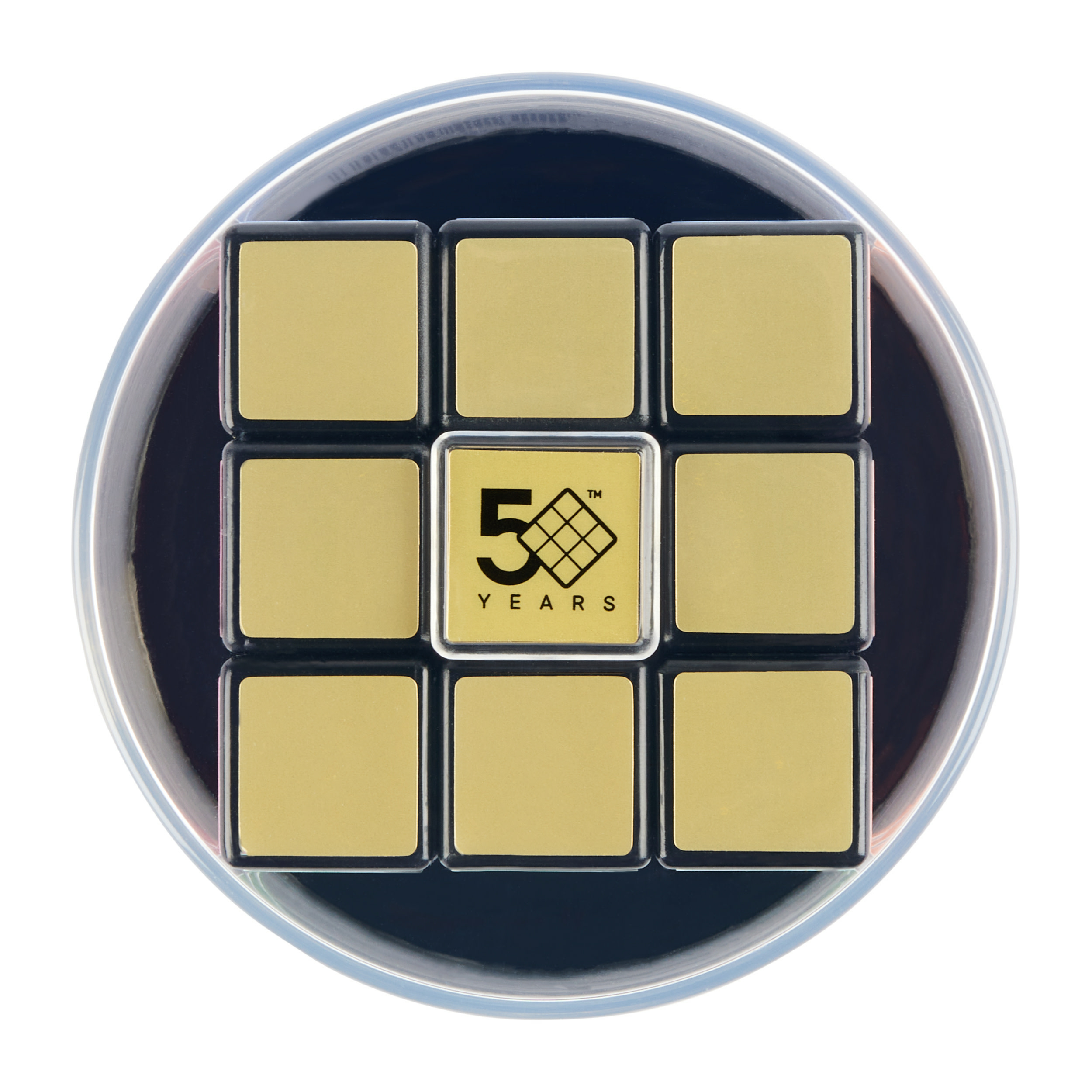 Un cubo di Rubik con un centro dorato celebra 50 anni. È all'interno di un contenitore trasparente con sfondo blu scuro.