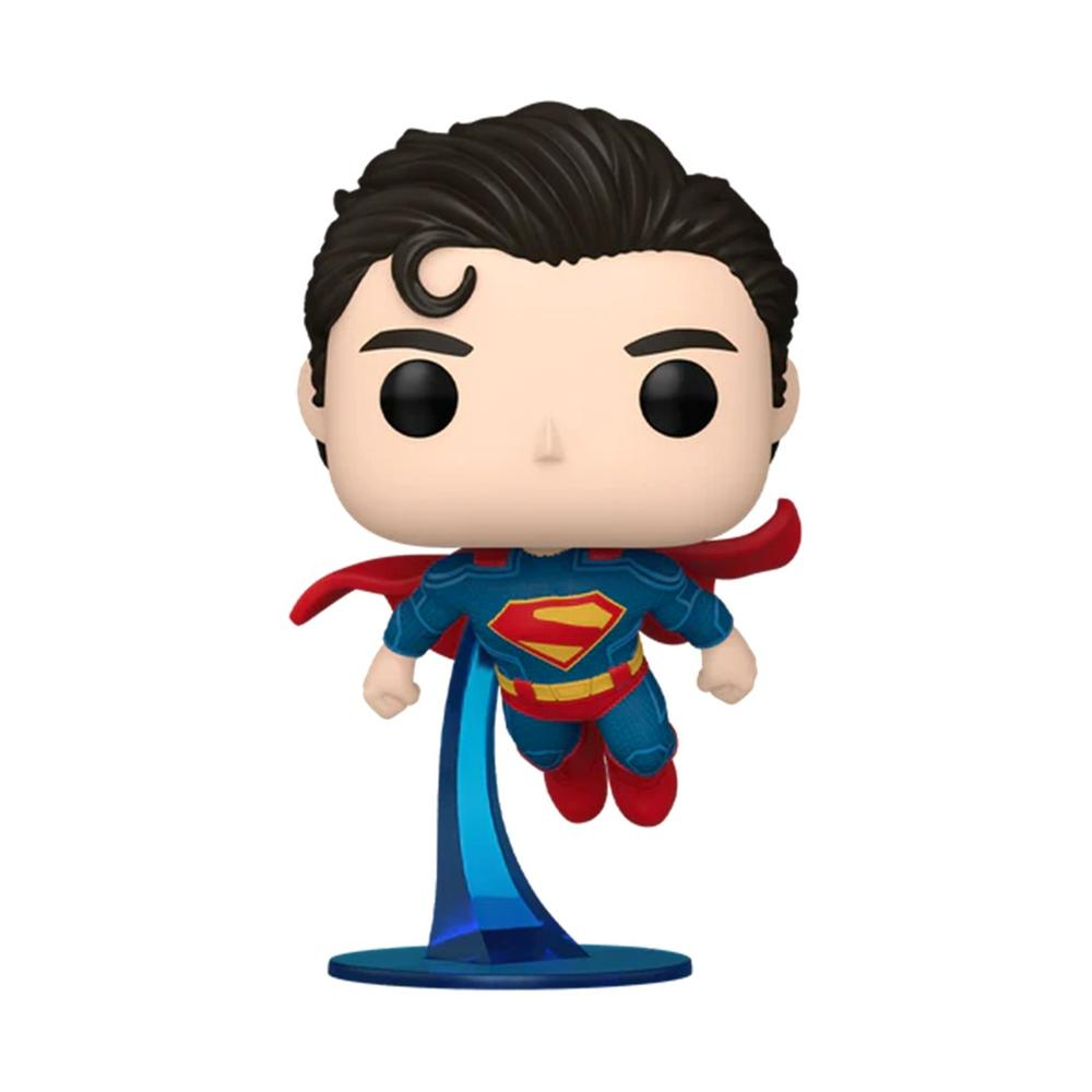 Figurka Superman Funko Pop. To bobblehead, ubrany w niebieski strój z czerwoną peleryną, latający z podporą.