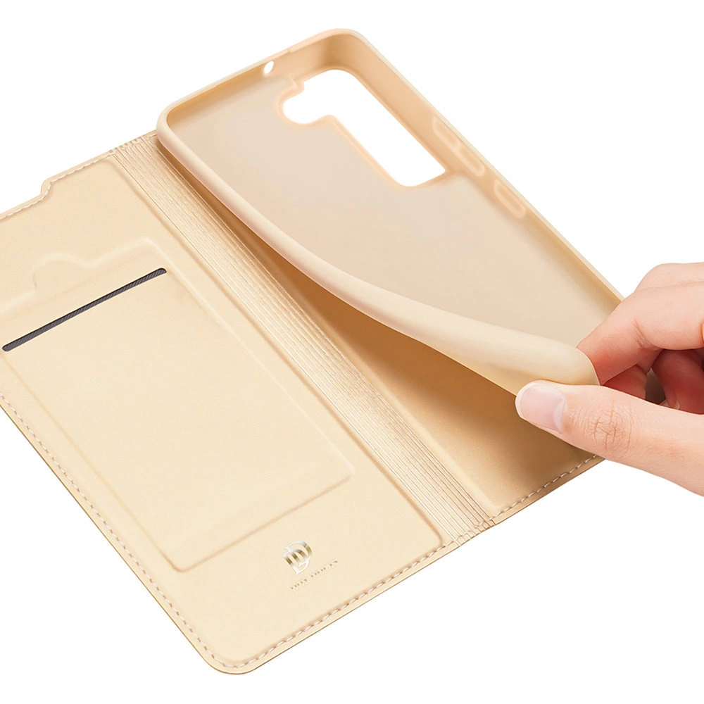 Una custodia beige per telefono è aperta, rivelando una tasca interna e il supporto per il telefono. Una mano apre ulteriormente la custodia.
