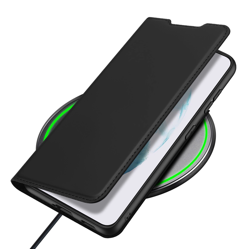 Un telefono nero in una custodia poggia su un caricabatterie wireless. Il caricabatterie ha una luce verde. La custodia del telefono è aperta.