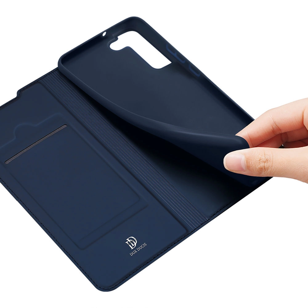Una custodia blu navy per telefono è mostrata aperta. Una mano solleva una copertura. L'interno rivela uno slot per schede e il marchio DUx DUCIS.