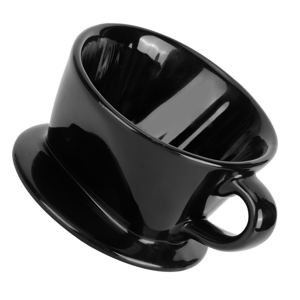Eine geneigte schwarze Keramik-Kaffeetasse. Sie hat einen Henkel und einen breiten Boden. Die Tasse ist glänzend und reflektiert Licht.