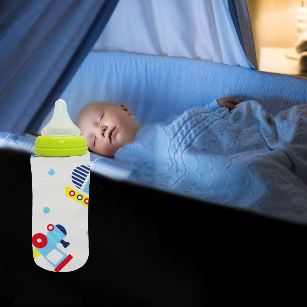 Eine Babyflasche mit bunter Hülle vor einem schlafenden Baby in einer Krippe, unter einer Decke.