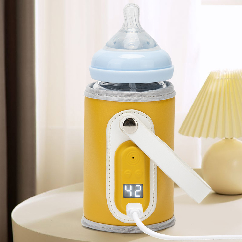 Ein gelb-weißer Babyflaschenwärmer mit Flasche, der die Temperatur 42 anzeigt. Im Hintergrund eine Lampe.