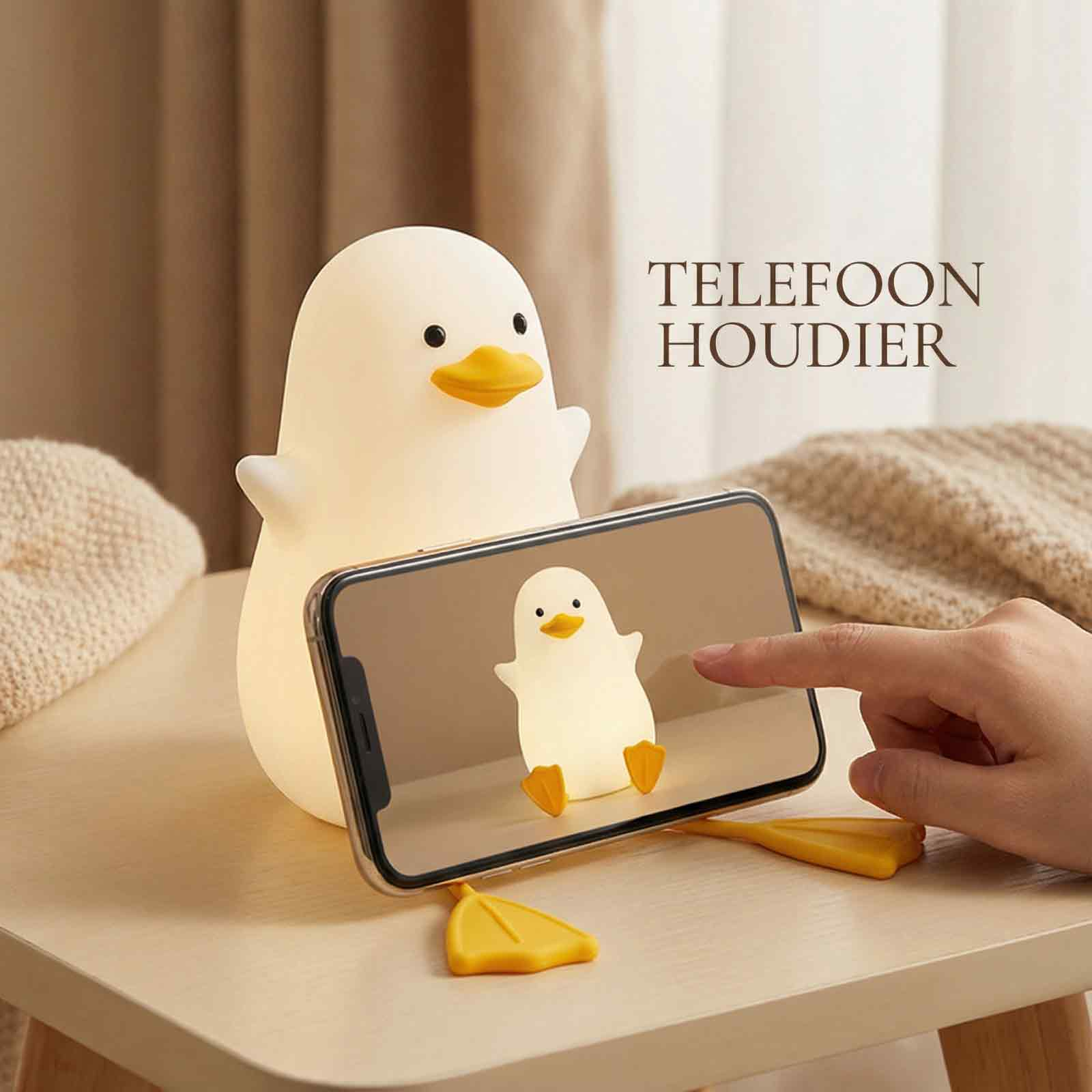 Eine ente-förmige Lampe hält ein Telefon. Das Telefon zeigt ein Entenbild. Eine Hand berührt den Bildschirm. Text: TELEFOON HOUDIER.