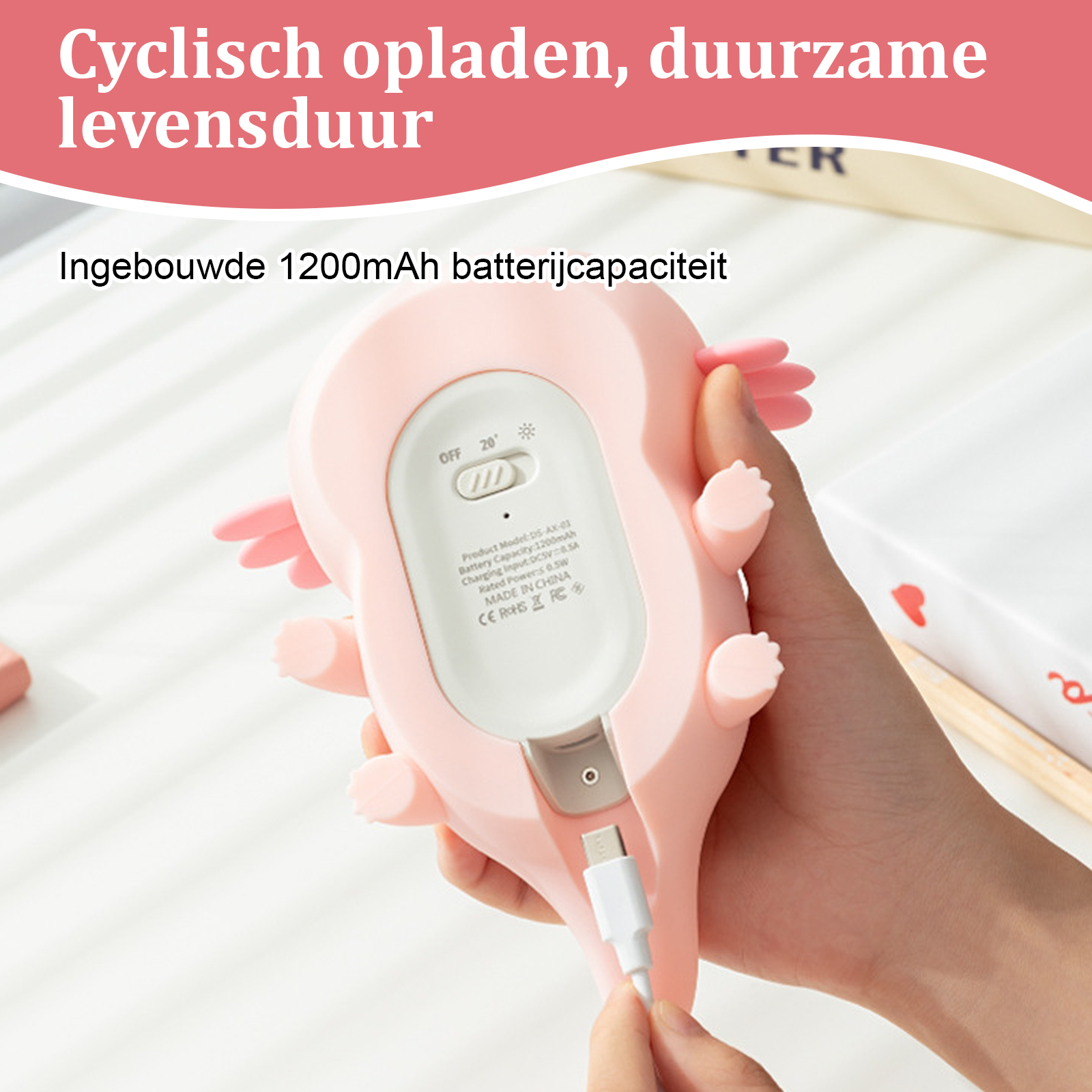 Ein rosa, axolotl-förmiges Gerät, in das ein USB-Kabel eingesteckt wird. Es hat einen Ein-/Ausschalter und Text auf der Rückseite.