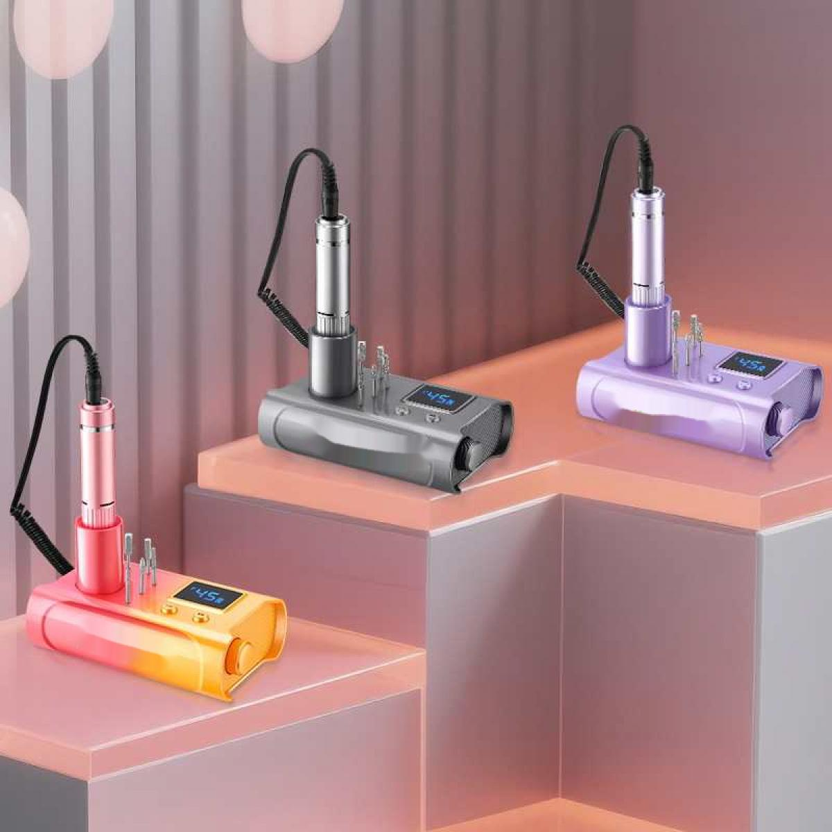 Drei Nagelbohrmaschinen, rosa, grau und lila, stehen auf einer mehrstufigen rosa Oberfläche. Jede hat ein Handstück und ein Display.