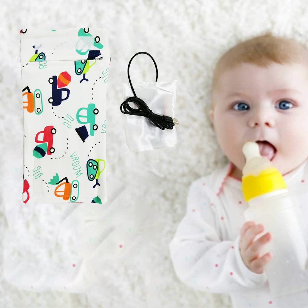 Baby mit Flasche, bunter Stoff mit Auto-Muster, USB-Kabel, alles auf einer weißen, flauschigen Oberfläche.
