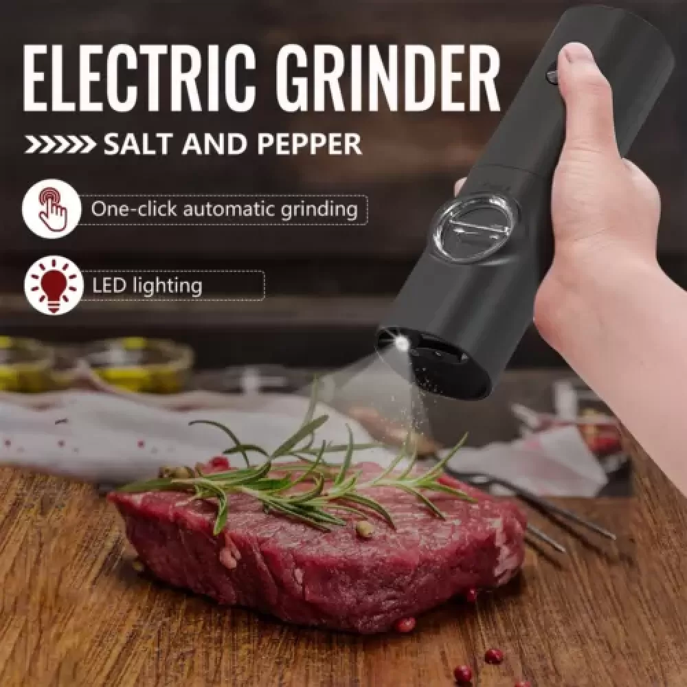Ein schwarzer elektrischer Grinder mahlt Salz auf ein Steak. Rosmarinzweige und eine Holzoberfläche sind ebenfalls sichtbar.