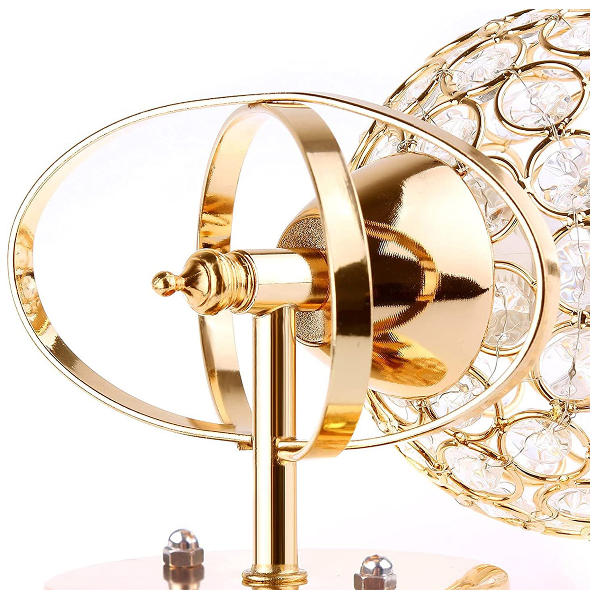 Nahaufnahme einer goldenen Lampe mit Kristallkugel. Die Lampe hat ein dekoratives Design und befindet sich vor weißem Hintergrund.