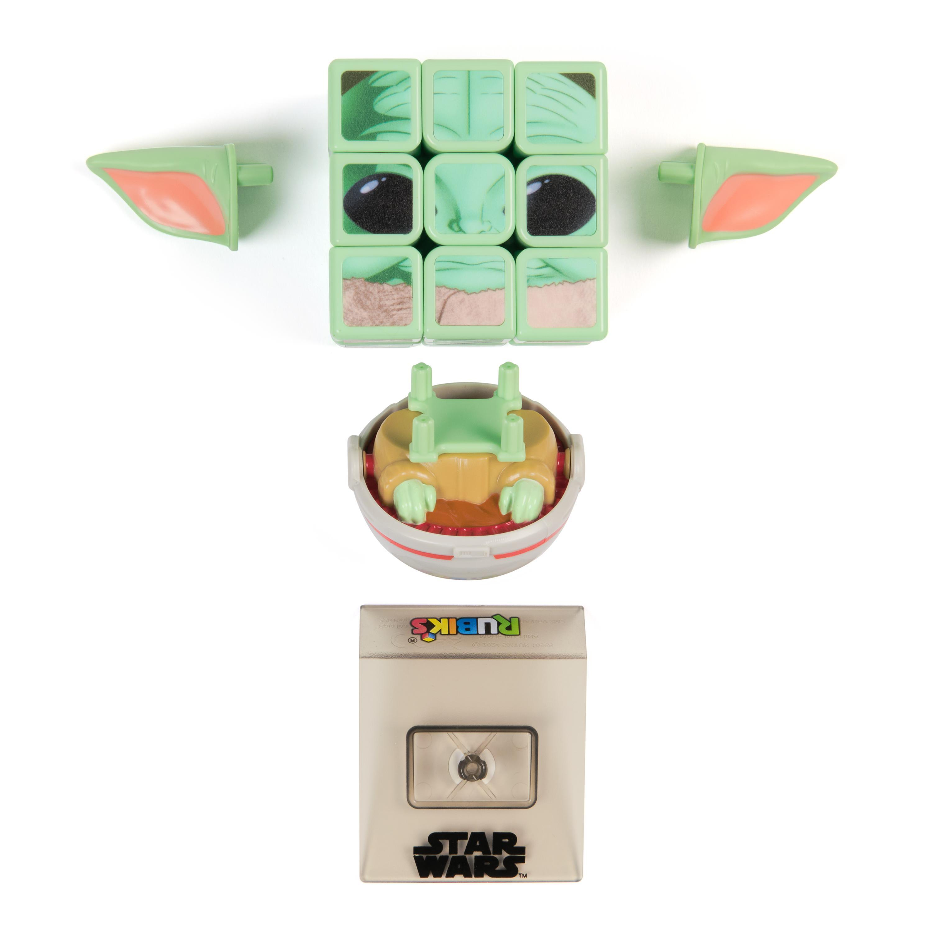 Ein Star Wars Rubik's Cube mit Grogu's Gesicht, Ohren und einer Kapsel, darunter eine Star Wars-Box.