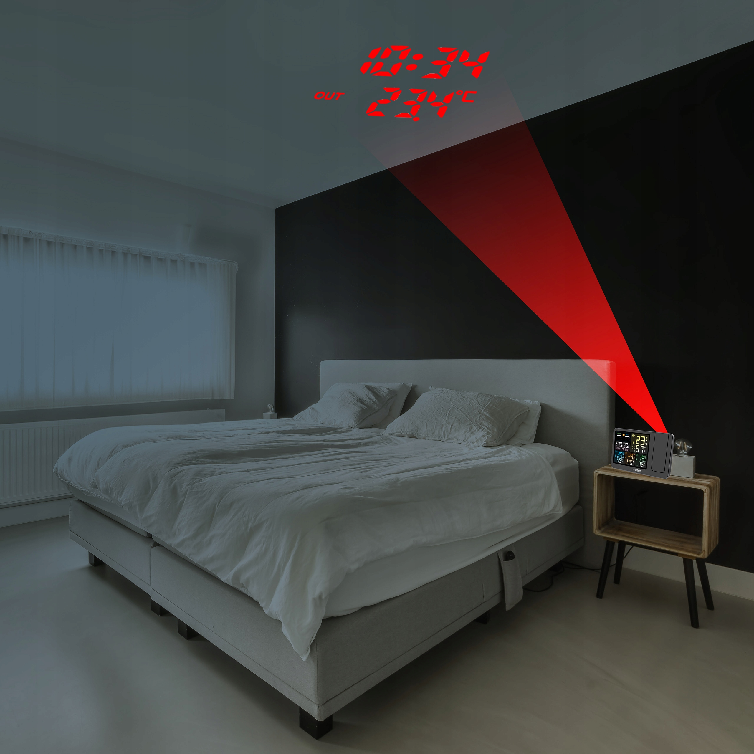 Sypialnia z łóżkiem, stolikiem nocnym i zegarem wyświetlającym godzinę i temperaturę na ścianie.