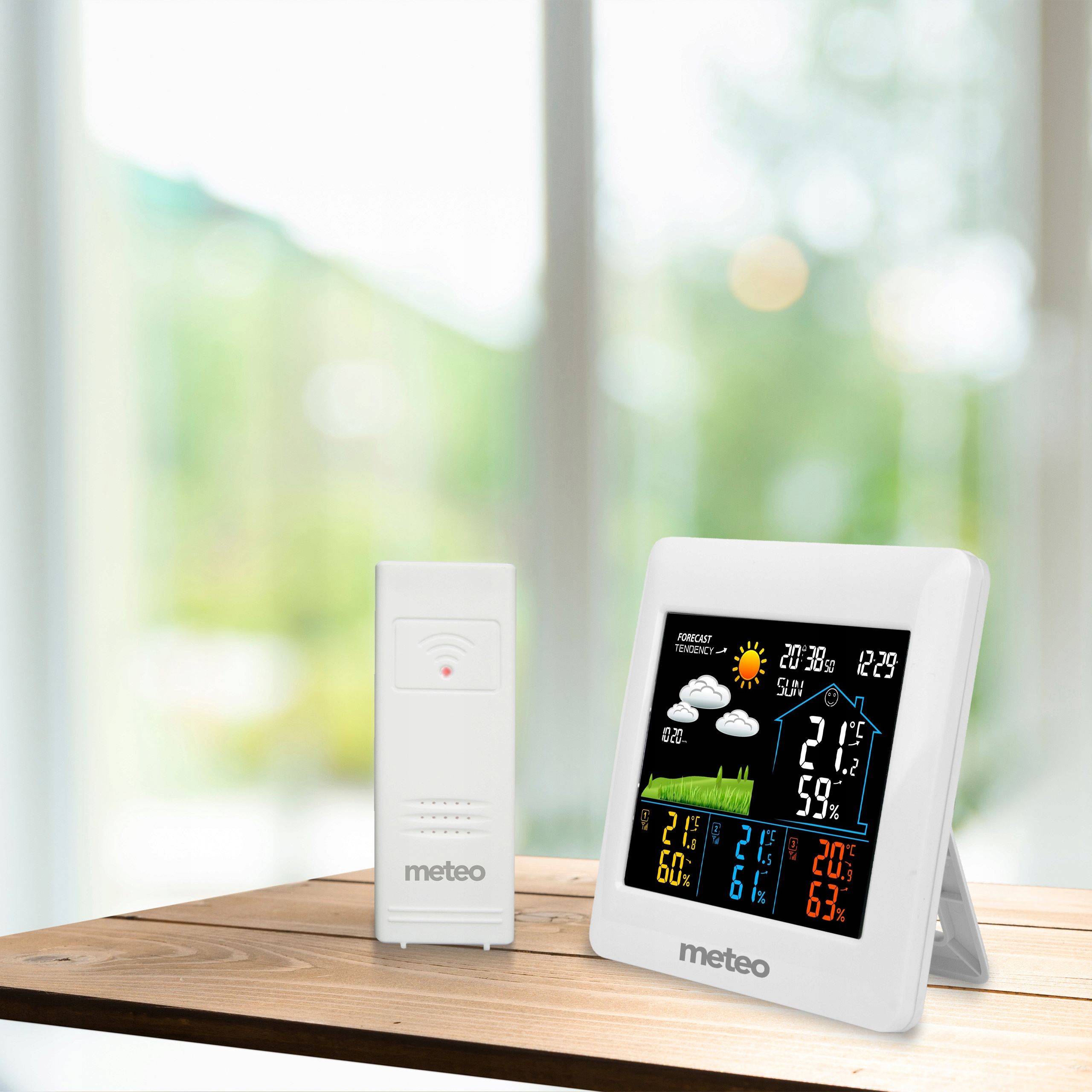 Biała stacja pogodowa z wyświetlaczem pokazującym czas, temperaturę i wilgotność oraz oddzielny czujnik.