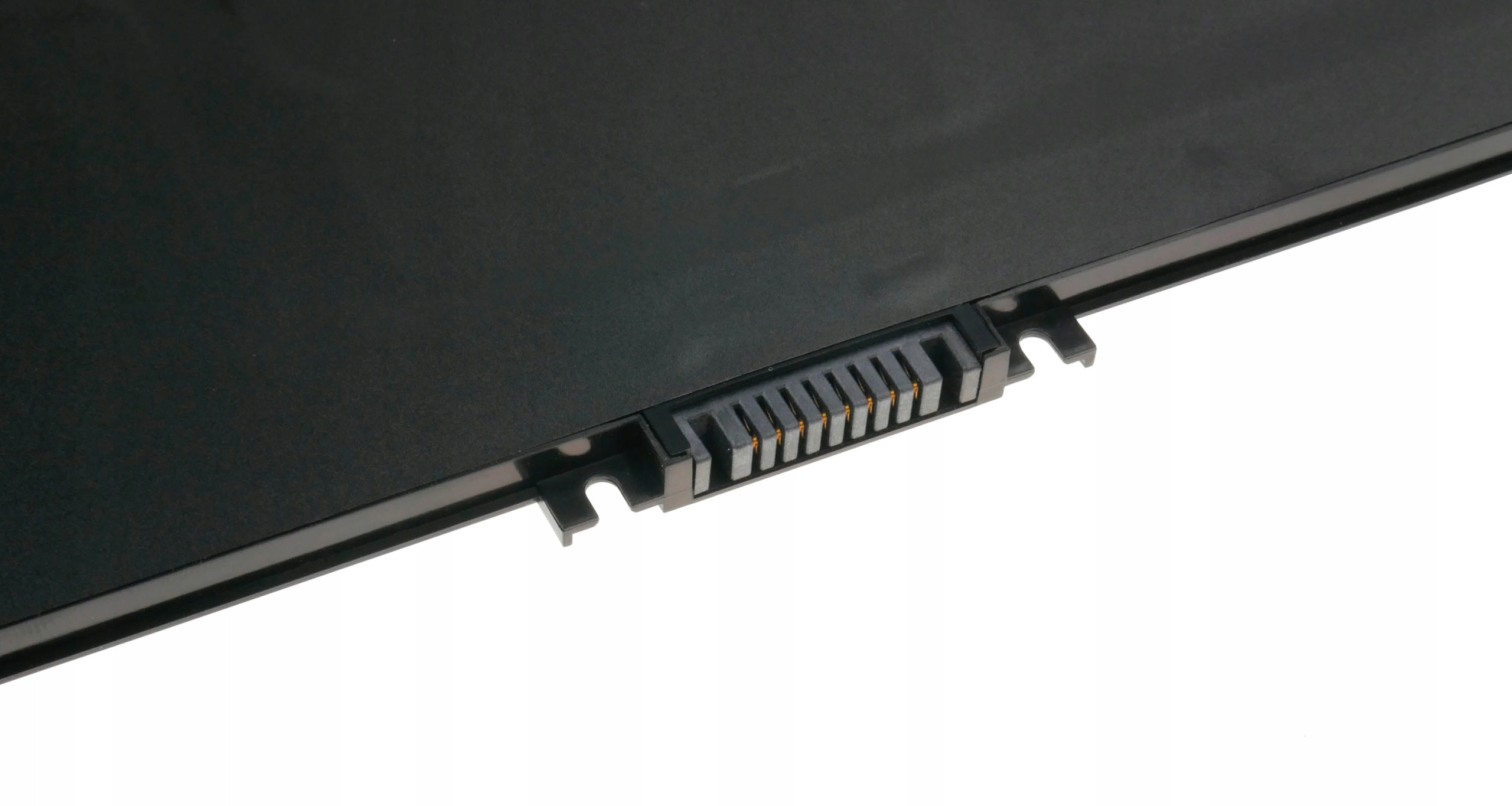 Czarna bateria do laptopa z widocznym złączem, na białym tle. Ujęcie z bliska z ostrością na złączu.