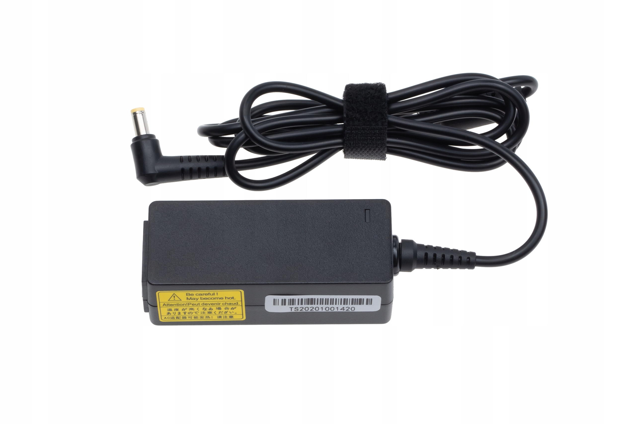 Czarna ładowarka do laptopa z kablem, naklejka z tekstem i znakiem ostrzegawczym, białe tło.