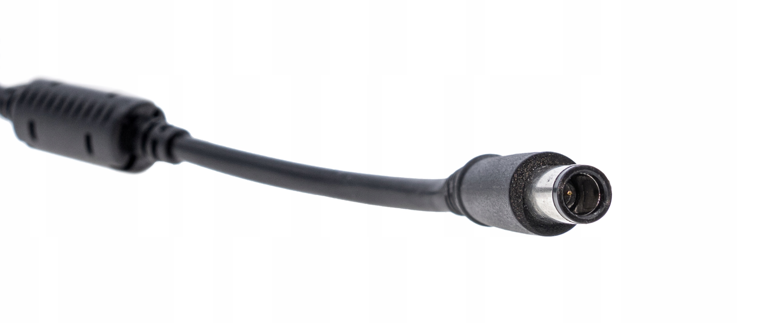 Czarny kabel zasilający z cylindrycznym złączem. Kabel na białym tle, ostrość na złączu.