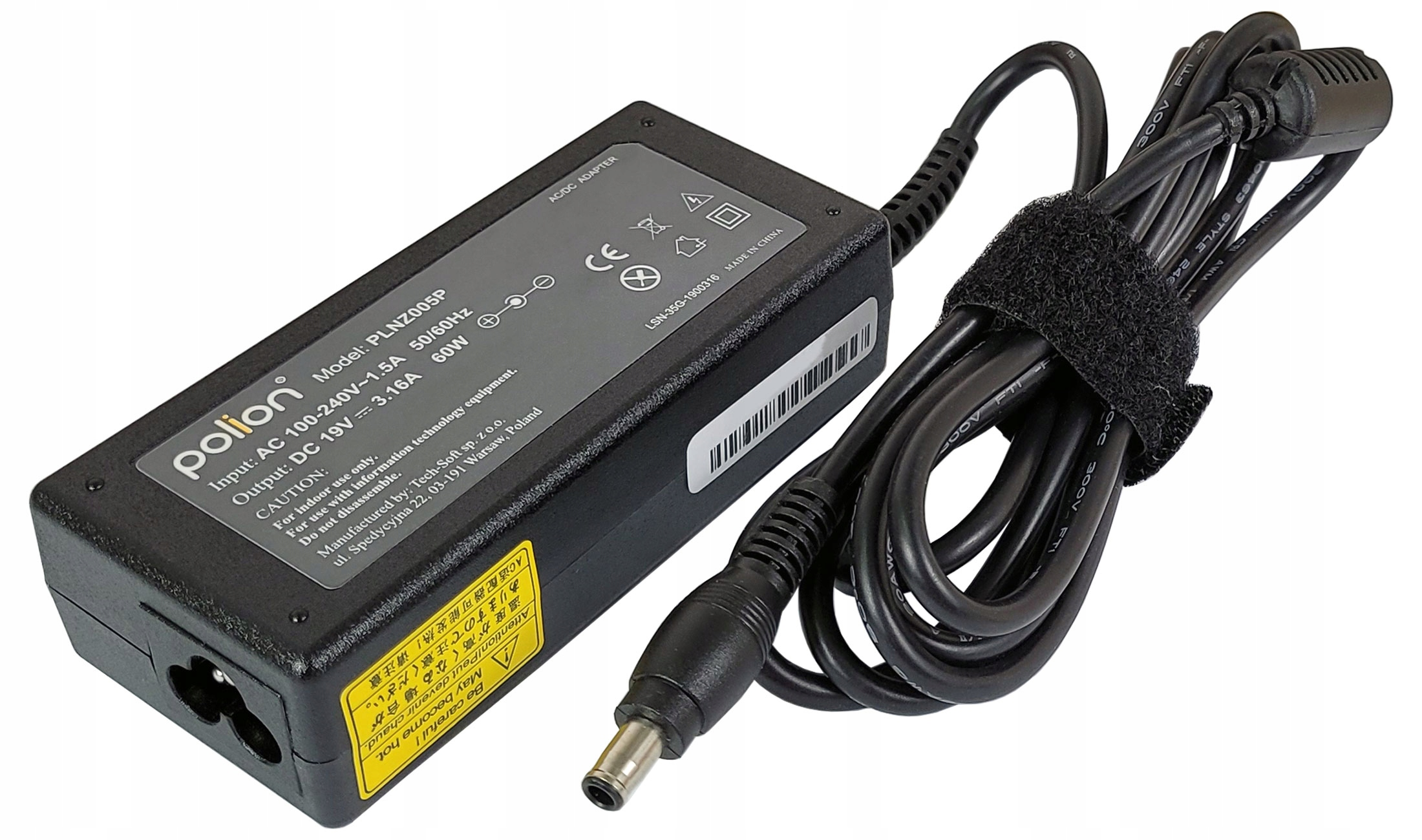 Czarny zasilacz Polion AC/DC z czarnym kablem i paskiem na rzep. Etykieta z napięciem wejściowym i wyjściowym. Żółta etykieta ostrzegawcza.
