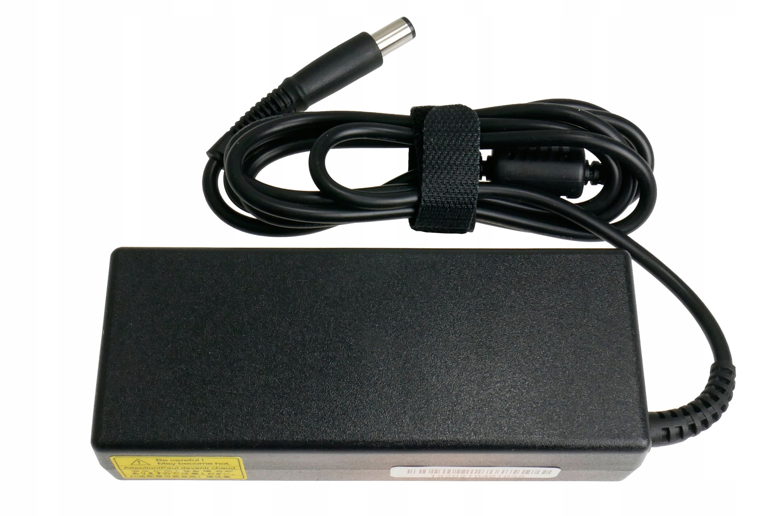 Czarna ładowarka do laptopa z czarnym kablem i etykietą na ładowarce. Kabel jest owinięty wokół ładowarki.