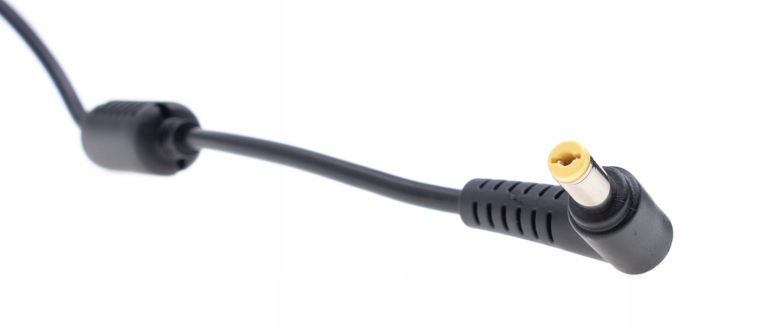 Czarny kabel do ładowarki laptopa z żółtą końcówką na białym tle. Kabel jest pod kątem.